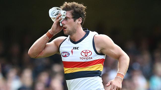 Kyle Hartigan of the Crows leaves the ground after a head clash against Brisbane. Picture: Jono Searle/AFL Photos/Getty Images