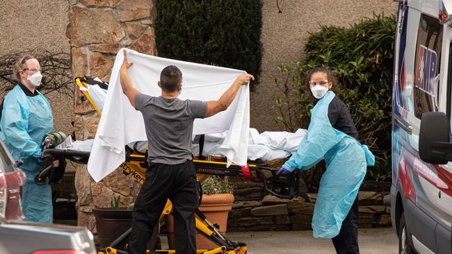 Healthcare workers transport a patient on a stretcher into an ambulance at Life Care Center of Kirkland in Kirkland, Washington, where dozens of staff and residents are reportedly exhibiting coronavirus-like symptoms. Picture: Getty Images