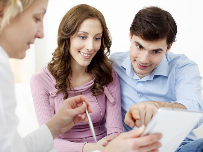 A young couple sorting out their home loan with a mortgage broker. Picture: iStock.