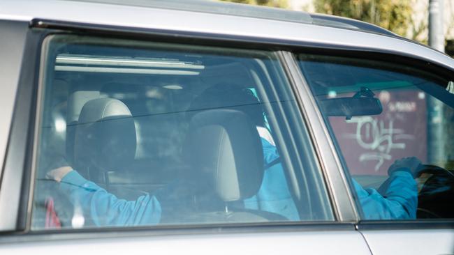 A man leans into the back seat while driving through the intersection of Greenhill and Glen Osmond roads on Wednesday. Picture: Morgan Sette