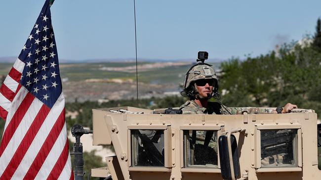 FILE - In this Wednesday, April 4, 2018 file photo, a U.S. soldier sits on his armored vehicle on a road leading to the tense front line with Turkish-backed fighters, in Manbij, north Syria. Even as President Donald Trump mulls a U.S. pullout, insisting that the Islamic State is â€œalmost completely defeated,â€ the extremist group is showing signs of resurgence in Syria. Talk of a U.S. troop withdrawal has alarmed the Unites Statesâ€™ main ally in Syria, the Kurds, who fought alongside the Americans to roll back the Islamic State group. (AP Photo/Hussein Malla, File)