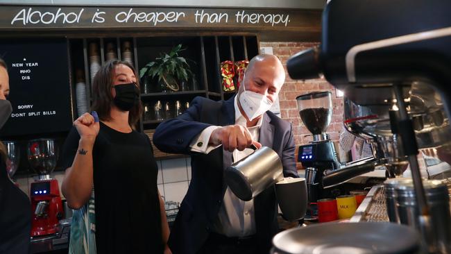 Froth test … Josh Frydenberg makes a coffee at a Mornington cafe in Victoria on Thursday. Picture: David Crosling