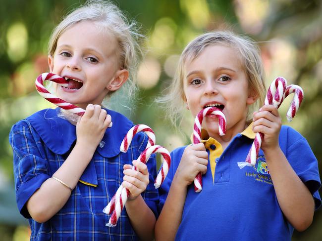 7-year-old Bronte Hawkins and 5-year-old Anika Hawkins, Teneriffe, enjoying candy canes which have been discouraged from many Queensland schools leading into Christmas. Pics Tara Croser.