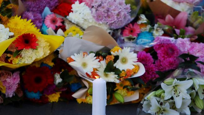 BONDI JUNCTION, AUSTRALIA - APRIL 14: A candle burns alongside flower tributes at Oxford Street Mall next to Westfield Bondi Junction on April 14, 2024 in Bondi Junction, Australia. Six victims, plus the offender, who was shot by police at the scene, are dead following a stabbing attack at Westfield Shopping Centre in Bondi Junction, Sydney. (Photo by Lisa Maree Williams/Getty Images)