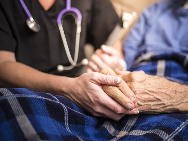 A stock photo of a Hospice Nurse visiting an Elderly male patient who is receiving hospice/palliative care.