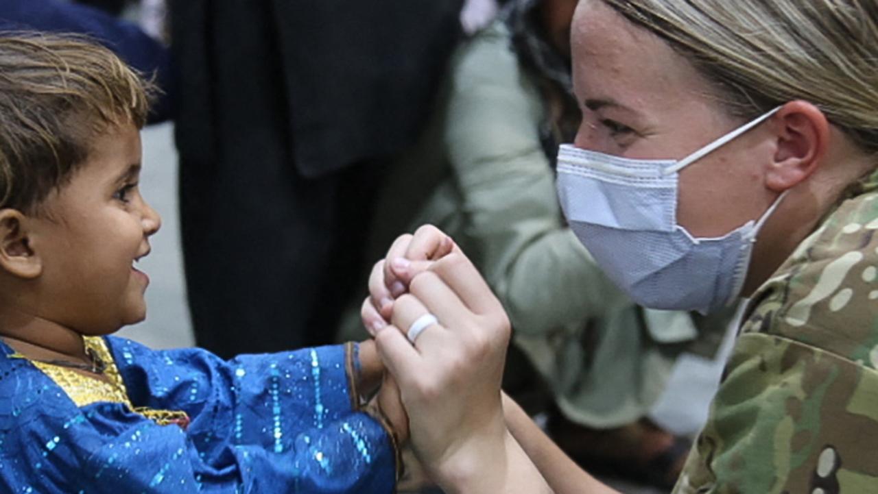 A member of the US Army speaking to an evacuated Afghan child. Picture: Marc Loi/US Army/AFP