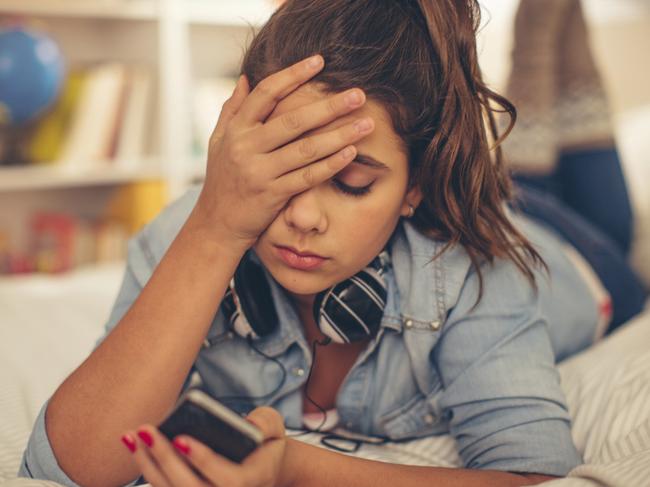 Teenage girl lying on bed in her room and checking smart phone. smartphone iphone sexting for insight