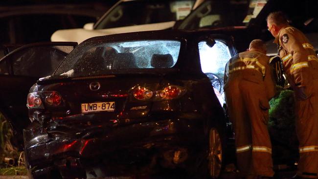 Firefighters examine the Mazda after the driver was taken to hospital. Picture: Patrick Herve