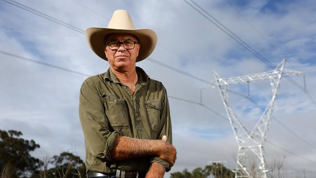 Farmer Andrew Campbell with the existing transmission lines on his farm in Stubbo, in Western NSW. Andrew is angry about having much larger transmission lines going up within metres of his home. Picture: Jonathan Ng