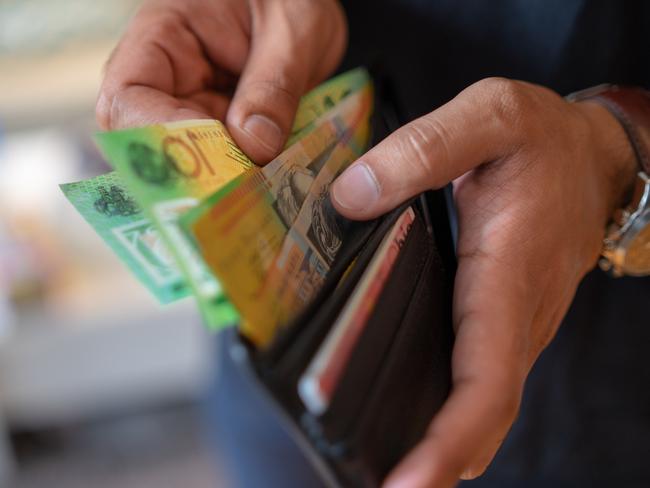 a male taking money out of a wallet, Australian cash generic spending