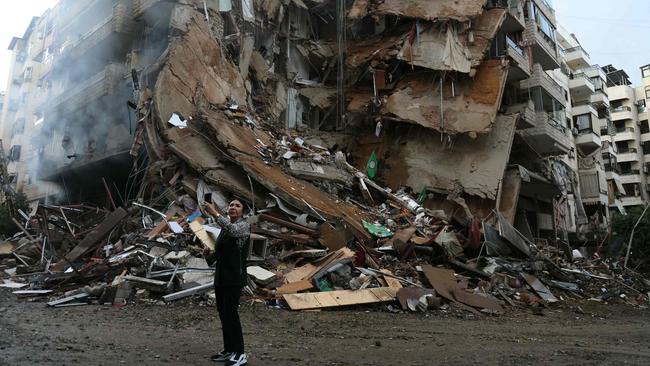 A woman takes a picture at the site of overnight Israeli airstrikes that targeted Tayouneh area in Beirut’s suburbs on Monday. Picture: AFP