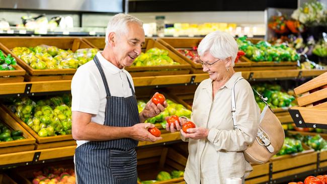 A senior worker and customer discussing vegetables in a supermarket. A lot of Australian workers do not like to reveal their ages.