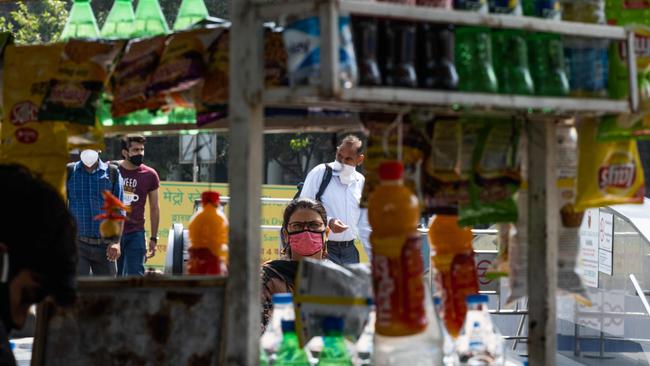 People wearing facemasks outside a metro station in New Delhi on Monday. India has reported its six millionth coronavirus case. Picture: AFP