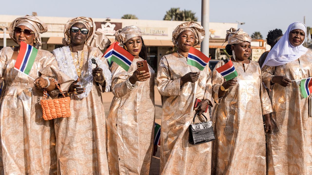 Supporters wave Gambian flags along the highway as President Adama Barrow arrives at the Organisation of Islamic Cooperation 2024 Summit. Picture: Muhamadou Bittaye/AFP