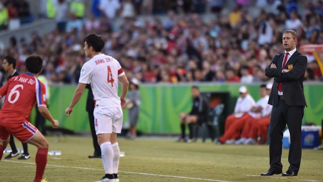 China coach Alain Perrin of France watches the game against DPR Korea.