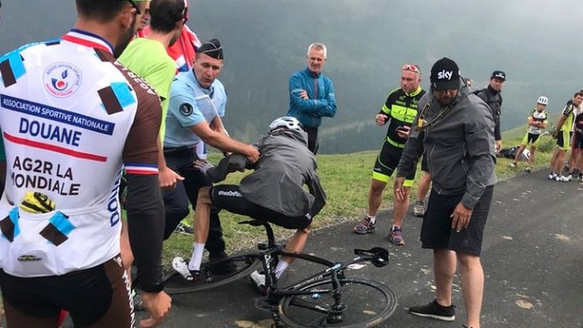 Froome is tackled by a policeman after finishing Stage 17