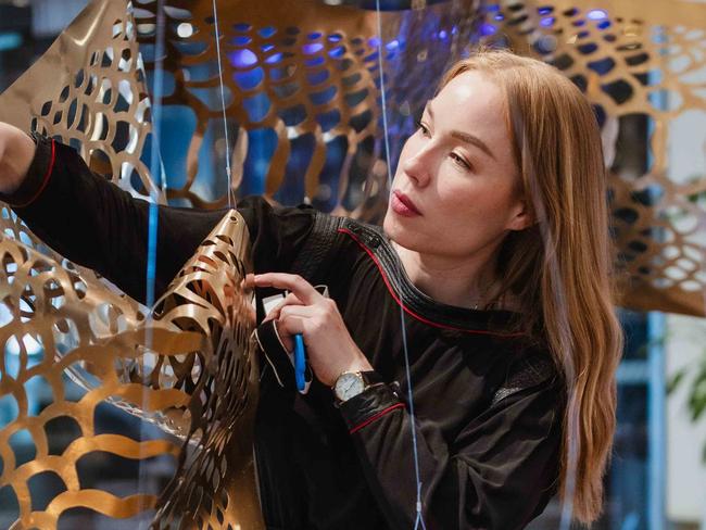 Elysha Rei installing her work (Seijaku): Serenity at Brisbane Quarter in celebration of The Asia Pacific Triennial exhibition at QAGOMA, 2025. Photograph: PixelPunk 2025, courtesy the artist.