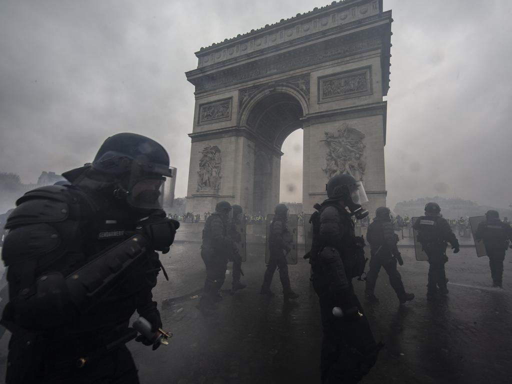 Tear gas surrounds riot police as they clash with protesters during a 'Yellow Vest' demonstration near the Arc de Triomphe. Picture: Getty