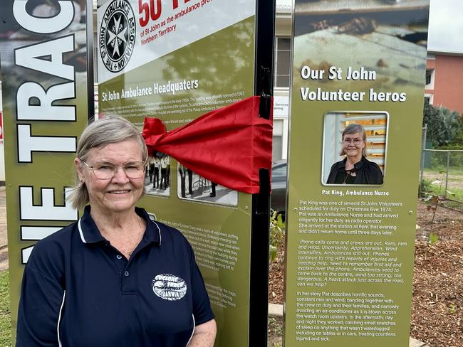 Pat King stands beside her personal story on a Cyclone Tracy commemorative sign at the St John Parap Station. Picture: Sam Lowe