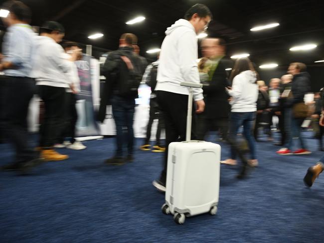 A smart artificial intelligence (AI) Ovis suitcase by ForwardX follows exhibitor Zhaoqiang Chen through the hall at CES Unveiled, the preview event for CES 2019 consumer electronics show, January 6, 2018 in Las Vegas, Nevada. The suitcase, with five cameras in the handle and precision obstacle avoidance technolgy, "walks" beside users providing hands-free travel experience. (Photo by Robyn Beck / AFP)