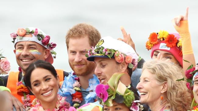 SYDNEY, AUSTRALIA - OCTOBER 19:  Prince Harry, Duke of Sussex and Meghan, Duchess of Sussex pose with Grant Trebilco and Sam Schumacher, founder and co-founder of OneWave, a local surfing community group raising awareness for mental health and wellbeing and their members on Bondi Beach on October 19, 2018 in Sydney, Australia. The Duke and Duchess of Sussex are on their official 16-day Autumn tour visiting cities in Australia, Fiji, Tonga and New Zealand.  (Photo by Ryan Pierse/Getty Images)