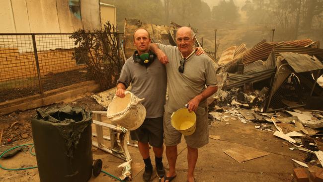 Jamie Gould and Frank Thatcher worked together to save several houses using buckets. Picture: Rohan Kelly