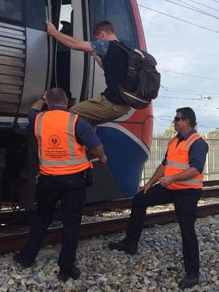 Passengers are helped off an electric train just north of the Seaford Meadows station after it stopped. Picture: Deborah Bogle