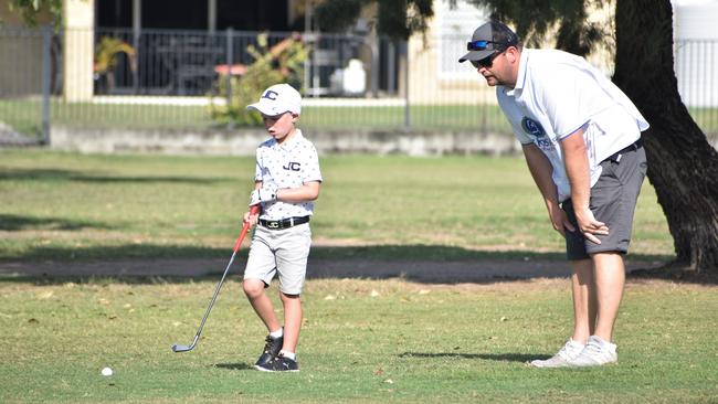 Brisbane's Mason Slavin (boys six years and under) discusses his next shot with Jay Slavin at the US Kids Golf Foundation Australian Open at the Rockhampton Golf Club on September 27.