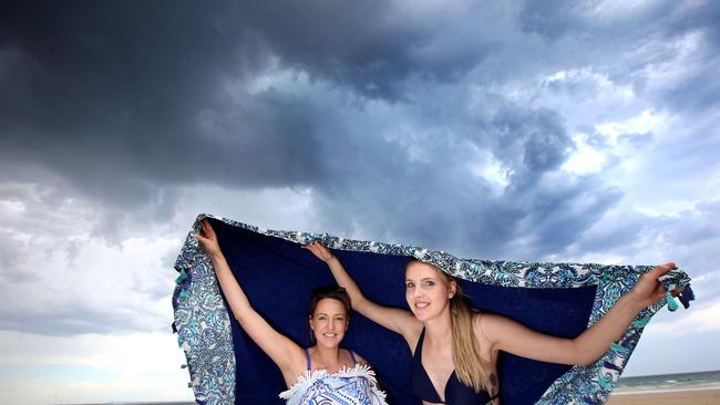 Lana Connor (Ocean Grove) and Jacqulin Pack (Altona) take cover under towel asthe first drops of  rain starts in Ocean Grove.  picture: Glenn Ferguson