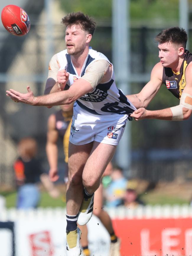 Bryce Gibbs dishes out a handball under pressure from Glenelg’s Riley Holder. Picture: Cory Sutton/SANFL.