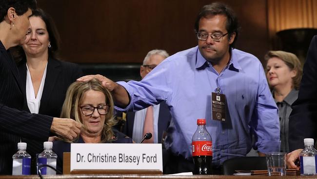 Family friend Keith Koegler pats Christine Blasey Ford on the head at the conclusion of her testimony before the Senate Judiciary Committee. Koegler provided a sworn statement saying Ford told him of the sex assault allegations. Picture: Win McNamee/Getty Images/pool