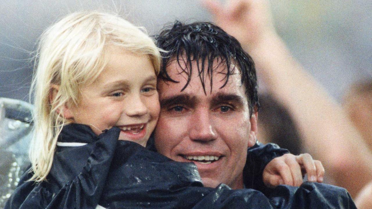 Footballer Greg Phillips hugging daughter Erin in 1992 after the SANFL Glenelg vs Port Adelaide grand final match. Picture: Neon Martin