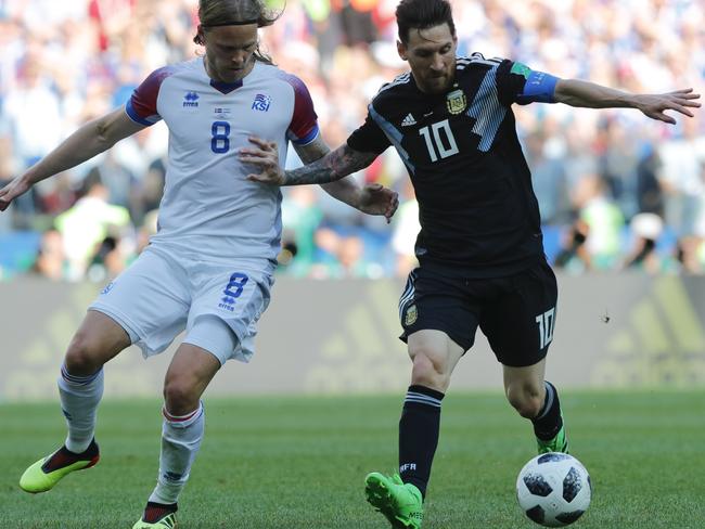 Lionel Messi is closely monitered by Birkir Bjarnason.