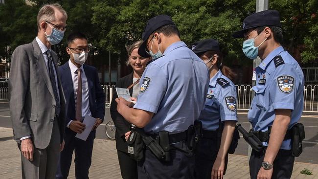 Police check the documents of Australian ambassador Graham Fletcher, who was denied entry to Yang Hengjun’s trial. Picture: AFP