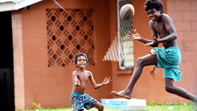 Xavier, 6, and John, 11, play football in the backyard.