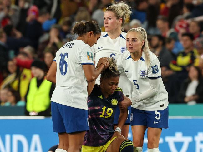 Colombia's midfielder #19 Jorelyn Carabali reacts as she is helped by England's defender #16 Jessica Carter and England's defender #05 Alex Greenwood during the Australia and New Zealand 2023 Women's World Cup quarter-final football match between Colombia and England at Stadium Australia in Sydney on August 12, 2023. (Photo by STEVE CHRISTO / AFP)