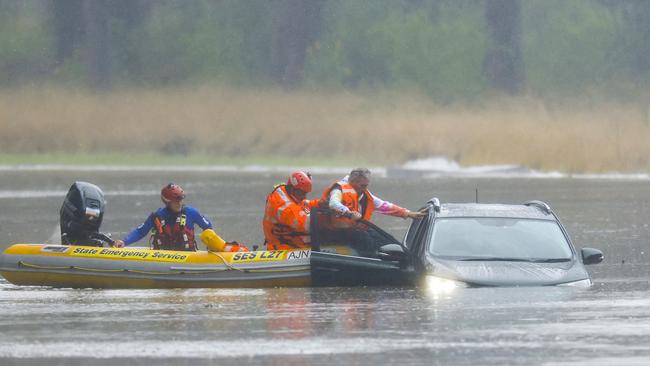 Others remain in the grip of the flood crisis. A man is rescued from his car by State Emergency Service workers in Windsor on July 4. Picture: Jenny Evans/Getty Images