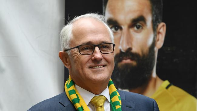 Australian Prime Minister Malcolm Turnbull adjusts his scarf as he stands on stage during a public celebration event for the Australian Socceroos in Martin Place in Sydney, Thursday, November 16, 2017. Ange Postecoglou?s side reached the 2018 World Cup in Russia with a 3-1 win over Honduras on Wednesday. (AAP Image/David Moir) NO ARCHIVING