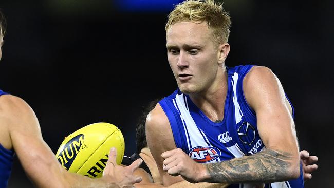 MELBOURNE, AUSTRALIA - MARCH 21: Jaidyn Stephenson of the Kangaroos handballs whilst being tackled during the round one AFL match between the North Melbourne Kangaroos and the Port Adelaide Power at Marvel Stadium on March 21, 2021 in Melbourne, Australia. (Photo by Quinn Rooney/Getty Images)