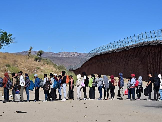 TOPSHOT - Migrants wait in line hoping for processing from Customs and Border Patrol agents after groups arrived at Jacumba Hot Springs, California, after walking under intense heat from Mexico into the US on June 5, 2024. Migrants from countries such as Turkey, Jordan, Guatemala, Nicaragua, China, India and Colombia made their way on foot into the United States today before being met with by Customs and Border Patrol agents for processing. The United States will temporarily close its Mexico border to asylum seekers starting today, June 5, as President Joe Biden as tries to neutralize his political weakness on migration ahead of November's election battle with Donald Trump. The 81-year-old Democrat signed a long-awaited executive order taking effect at midnight to "gain control" of the southern frontier with Mexico, after record numbers of illegal border crossings sparked concerns among voters. (Photo by Frederic J. BROWN / AFP)