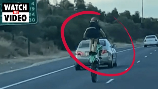 Speeding motorcyclist caught standing on bike (7NEWS)