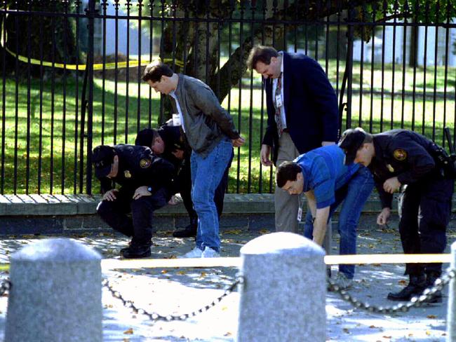 Secret Service man and police inspect the White House perimeter after the shooting.