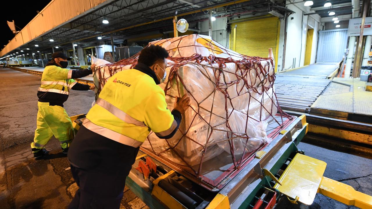 Airport workers move pallets of vaccines being unloaded after landing in Sydney. Picture: James D. Morgan/Getty Images