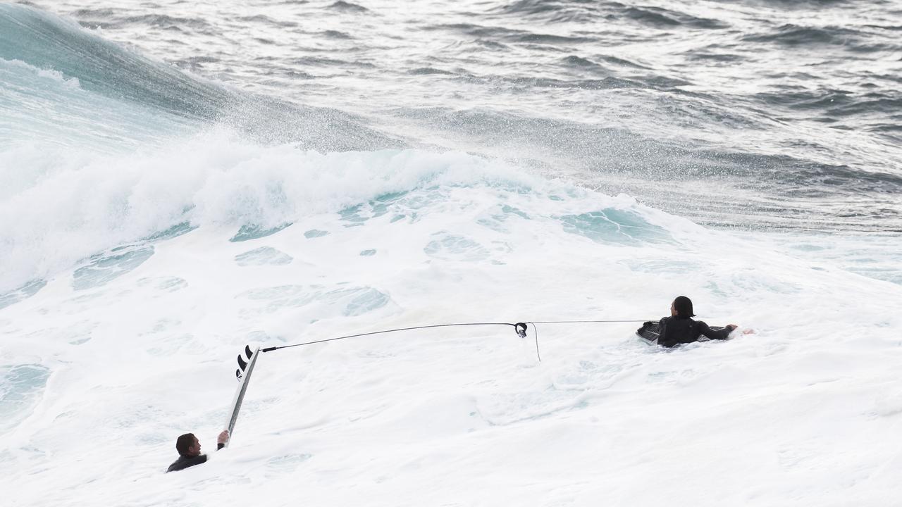 Surfers use jet skis to tow into large waves still around from the low pressure system at the Cape Solander surf break "Ours". Picture: Dylan Robinson