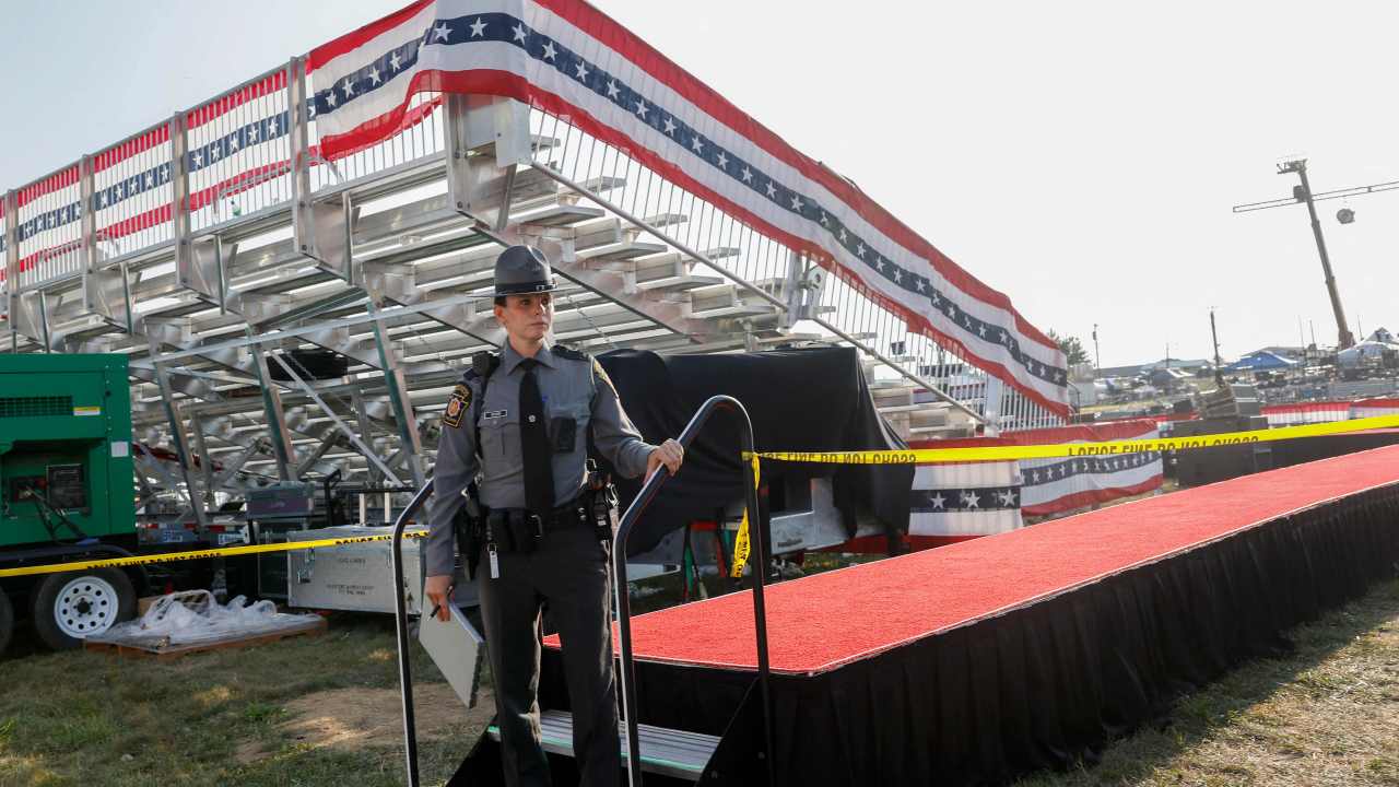 Law enforcement agents stand near the abandoned stage of a campaign rally for Republican presidential candidate former President Donald Trump after the shooting. Picture: Getty.