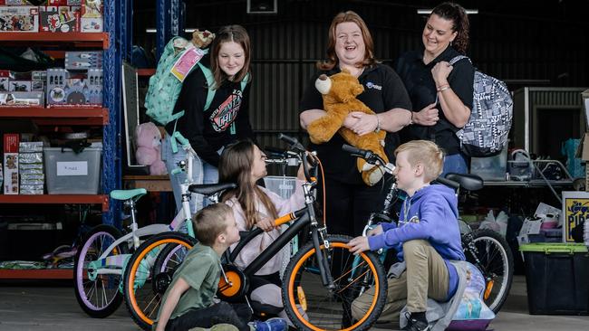 Rachael Zaltron and Kelly Barker from Backpack4SAKids, with Holly, 13, Lincoln, 7, Laetitia, 10, and Noah, 10, at the warehouse where they store the items going to disadvantaged families and children. Picture: AAP / Morgan Sette