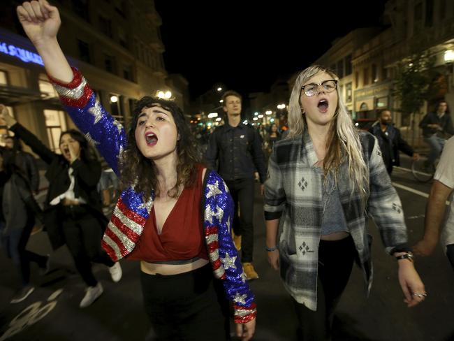 Madeline Lopes, left, and Cassidy Irwin, from Oakland have protested the election. Picture: Jane Tyska/Bay Area News Group via AP.