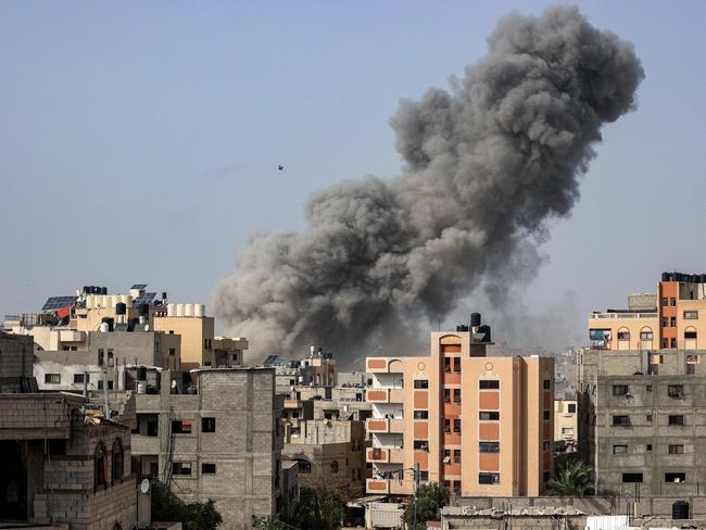 TOPSHOT - A bird flies past a plume of smoke towering during Israeli bombardment in Gaza City on April 18, 2024 amid the ongoing conflict in the Palestinian territory between Israel and the militant group Hamas. (Photo by AFP)