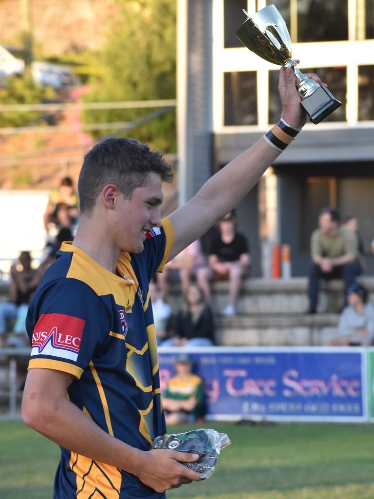 Gladstone State High co-captain Brodie Hunt hoists the trophy high after his team’s win in the Open C grand final.