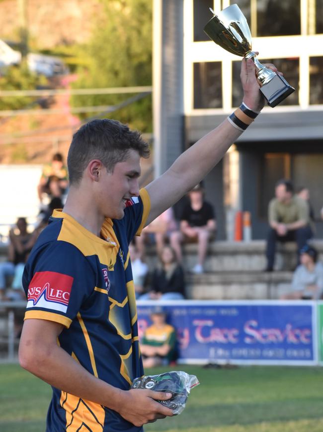 Gladstone State High co-captain Brodie Hunt hoists the trophy high after his team’s win in the Open C grand final.